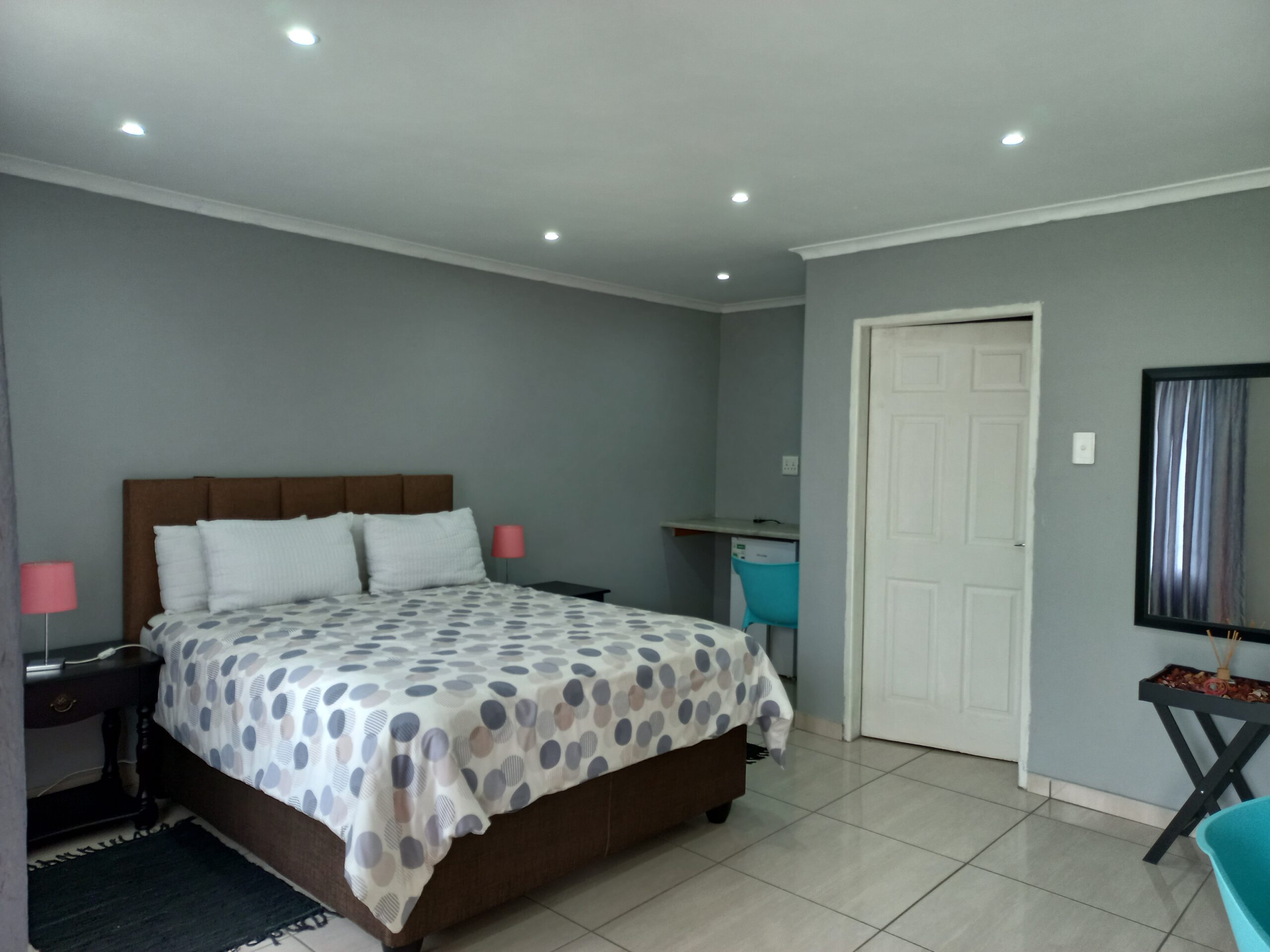 Spacious bedroom with a double bed, bathroom, and downlights